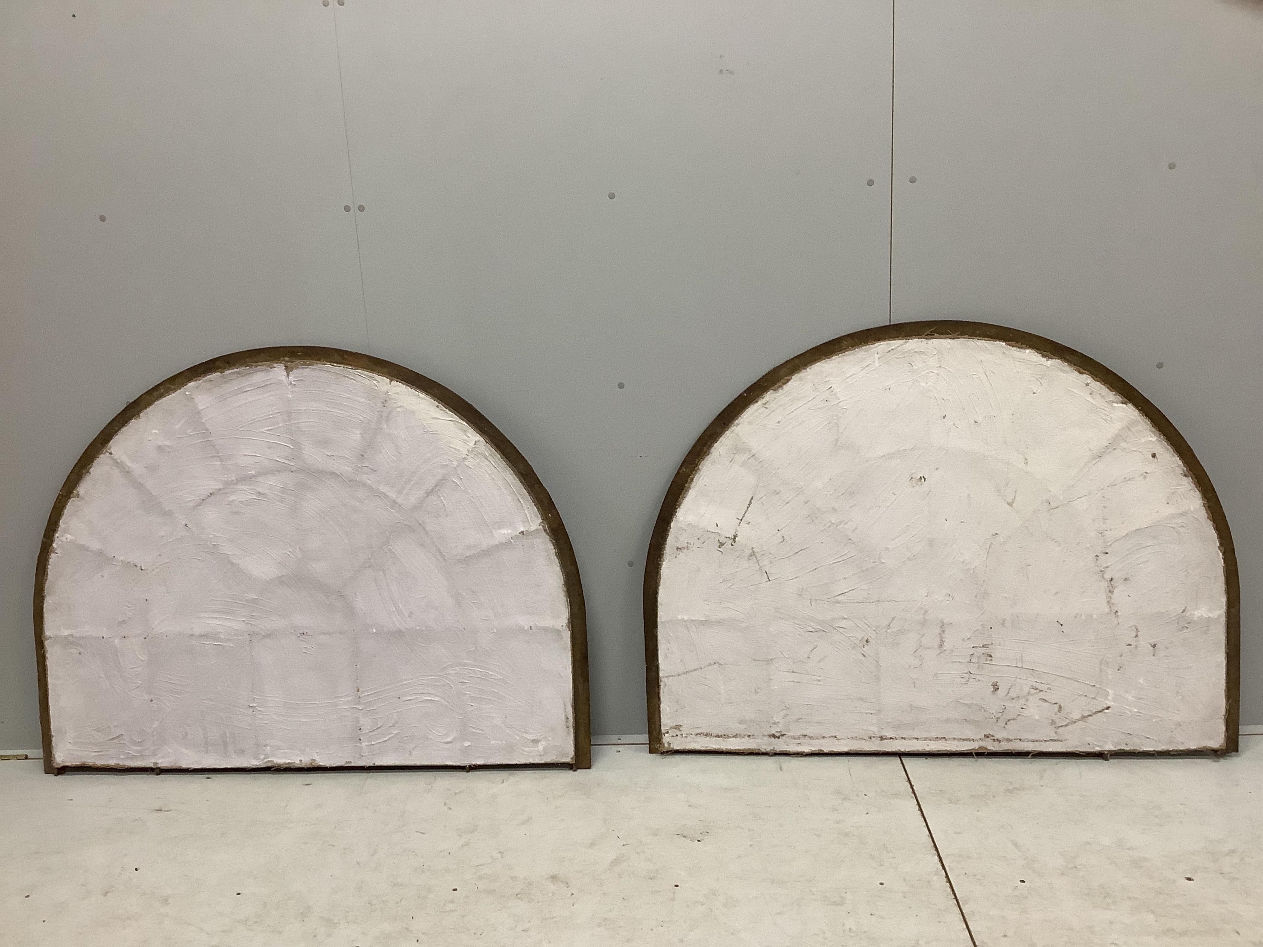 A pair of architectural cast iron window panel wall mirrors of domed form, width 136cm, height 102cm. Condition - fair, four panes cracked.